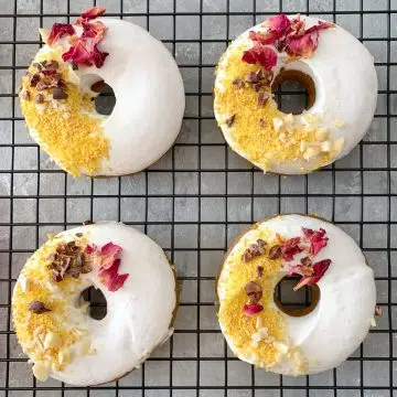 Raw Doughnuts - Four glazed doughnuts on a cooling rack