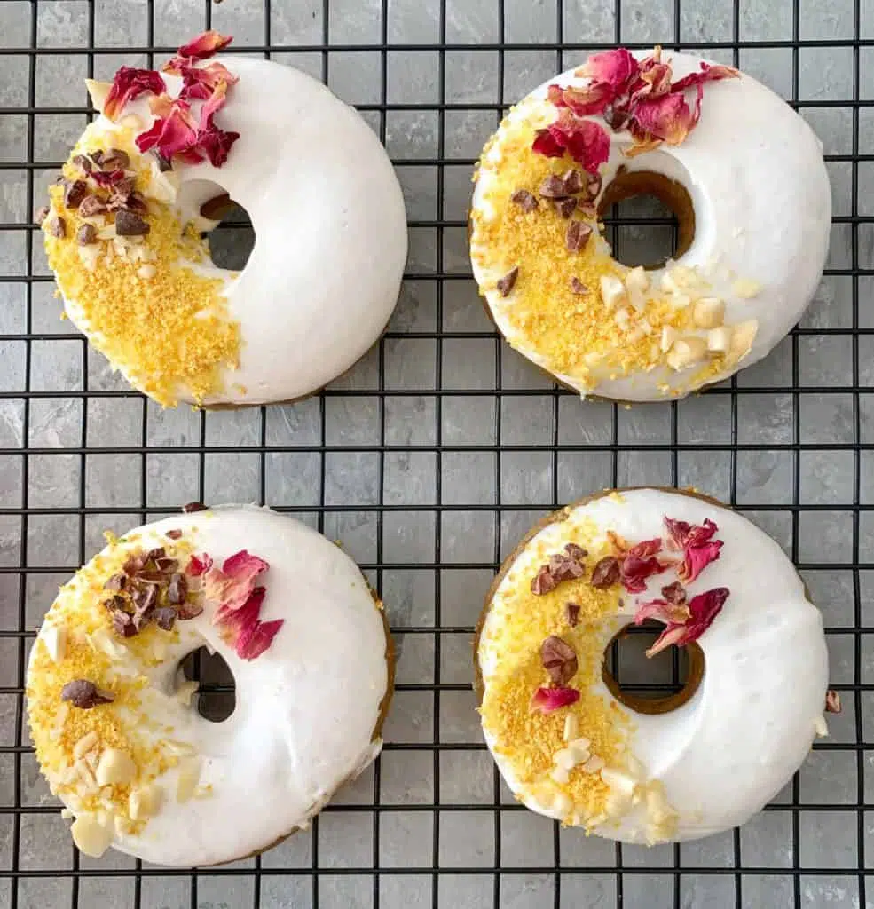 Raw Doughnuts - Four glazed doughnuts on a cooling rack