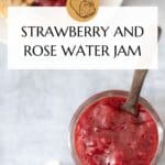 This image shows a pinterest poster, which includes the title of the recipe covering some of the background. The background image shows a small jar of strawberry and rose jam down the bottom right of the image with a small spoon made of wood protruding. Above this and to the left on the table is a white plate with two slices of toast. One has been spread with butter and the strawberry and rose jam.
