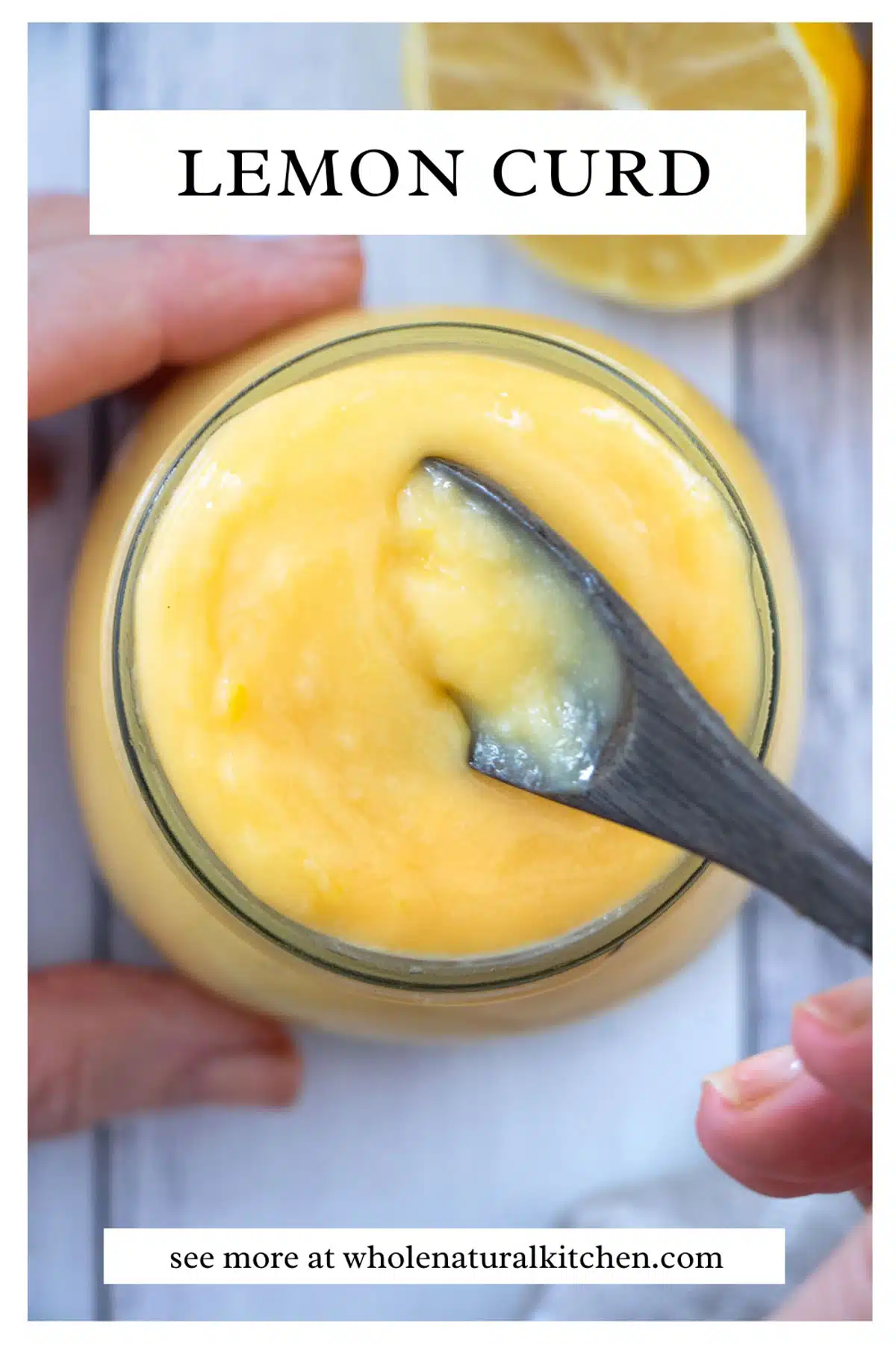 An image of a pinterest poster. The name of the recipe is at the top with a picture of the lemon curd in a small jar below it. The jar is being held by a white hand while another is dipping a small brown spoon in it to scoop some up. The website names is at the bottom of the image.
