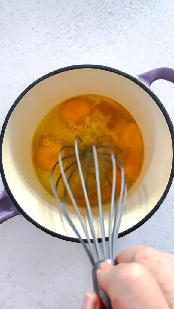All the lemon curd ingredients are being whisked together in a small saucepan before it's placed on the heat.
