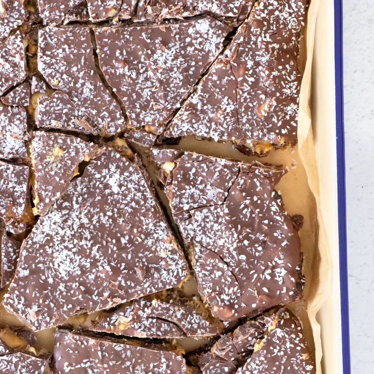 A square image showing a tray of chocolate date bark up close.