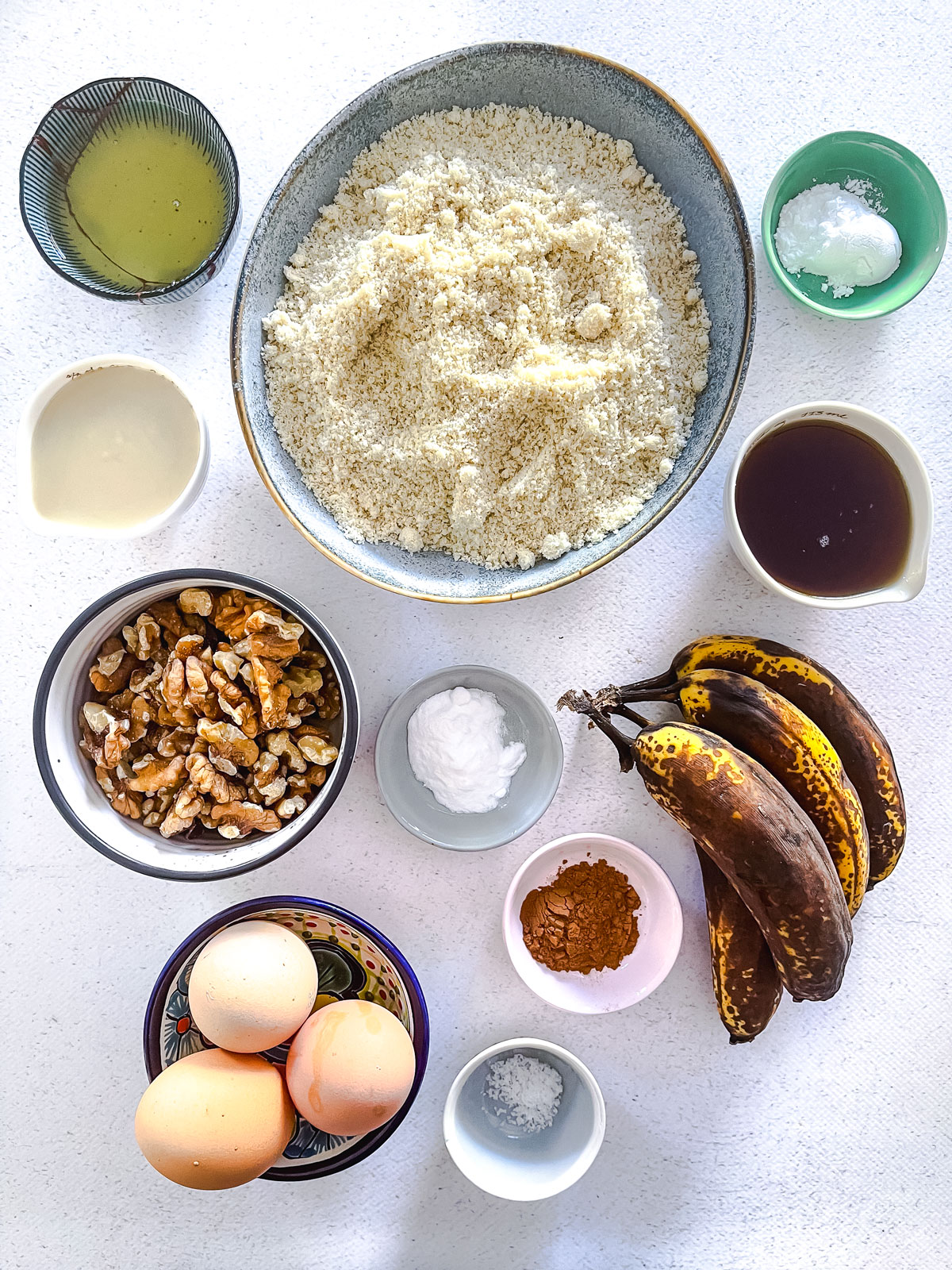 All the ingredients needed to make tahini banana bread have been laid out across the kitchen bench in various small bowls.