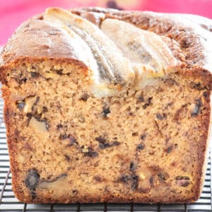 Close-up showing a cut section of banana bread loaf with choc chips and walnuts visible.