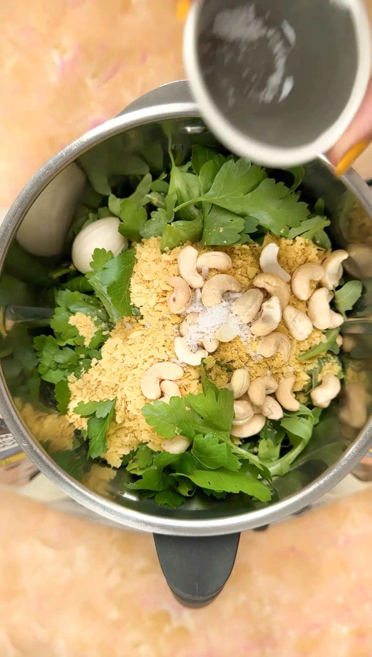 Looking down into a food processor that has been filled with all the rocket pesto ingredients.