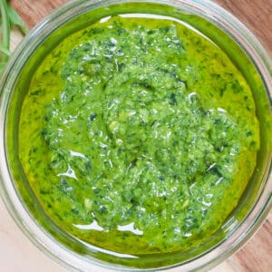 Close up looking into a jar of rocket pesto. The jar is completely filling the screen.