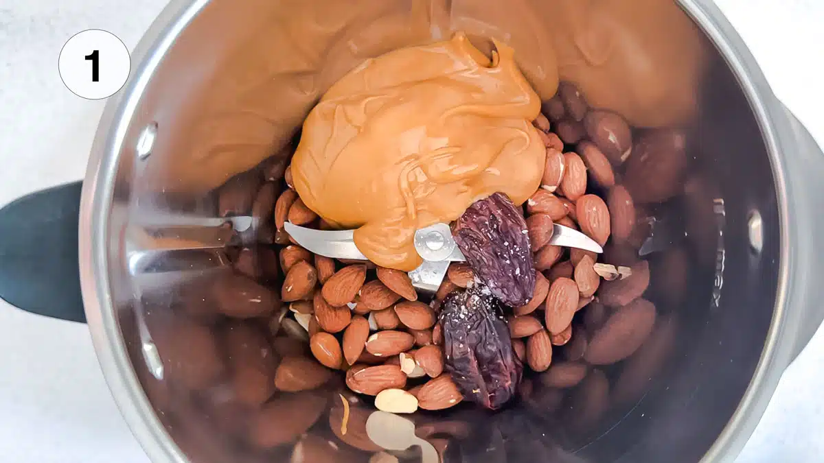 Looking into a blender to see nuts, dates and peanut butter before they're blended.