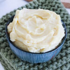 A small bowl of miso butter sits on an olive green knitted pot warmer.