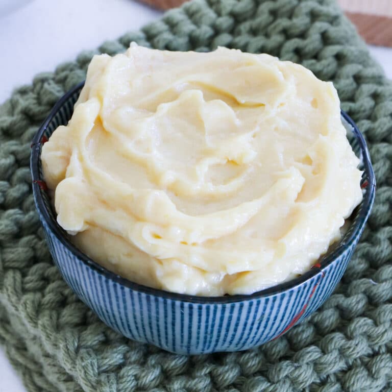A small bowl of miso butter sits on an olive green knitted pot warmer.