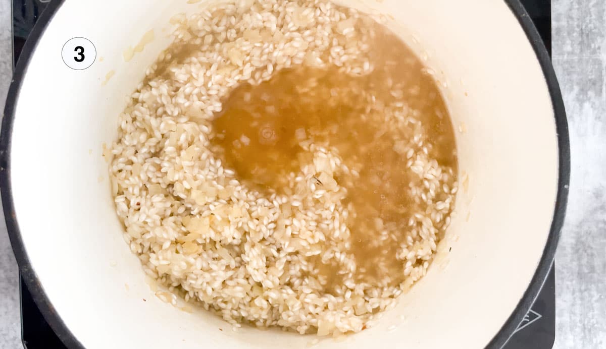Adding hot chicken stock to a wild mushroom risotto cooking on the stovetop.