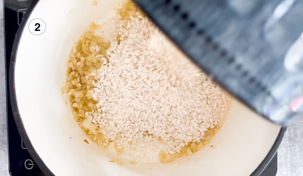 Pouring rice into a pot with onion, oil, and butter to make a wild mushroom risotto.