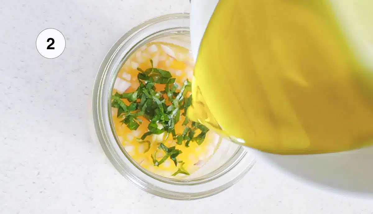 Pouring olive oil into a jar to make a vinaigrette dressing.