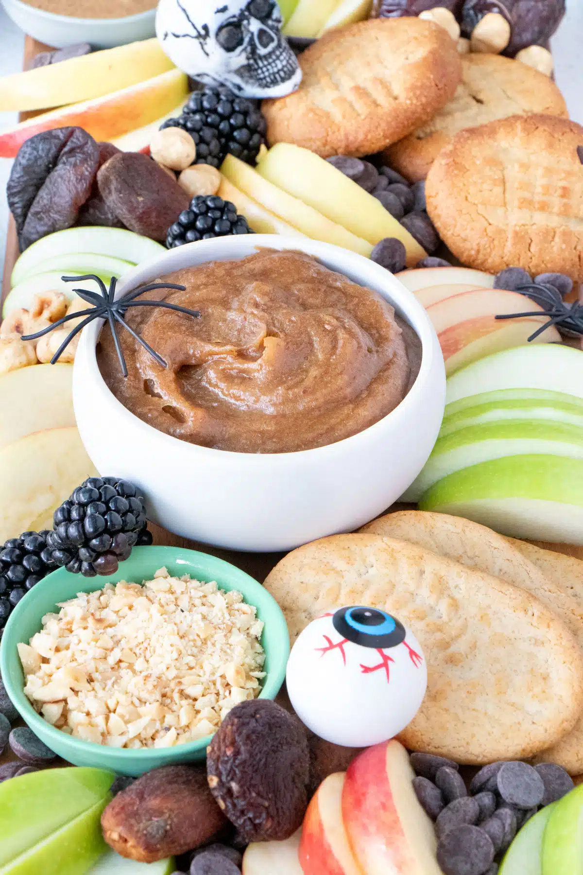 A close-up angled view of a caramel apple charcuterie board decorated for Halloween.