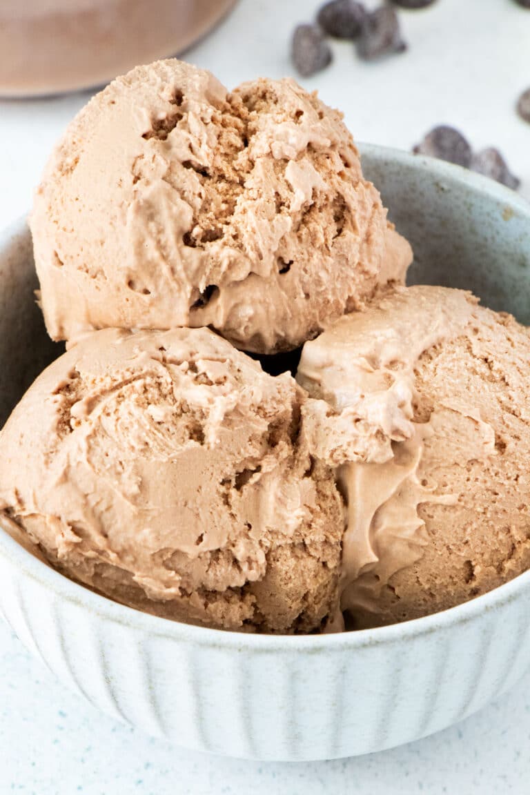 A small bowl filled with three scoops of Ninja Creami Chocolate Ice Cream sits on a table.