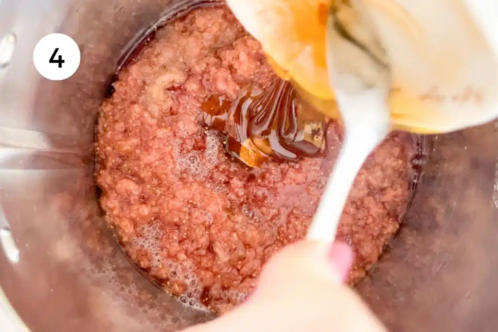 Pouring honey into a food processor with fermented fig puree.