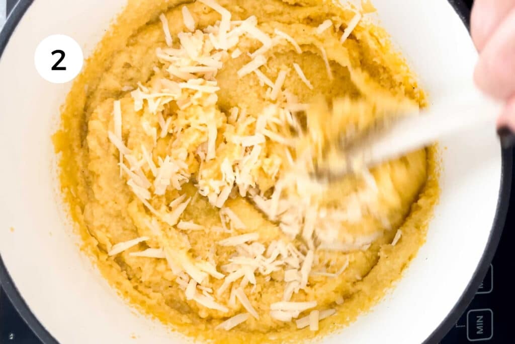 Stirring butter and parmesan cheese into a pot of cooked polenta.