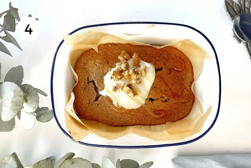 A small baking dish filled with Baked Oats for One is topped with yoghurt and walnuts.