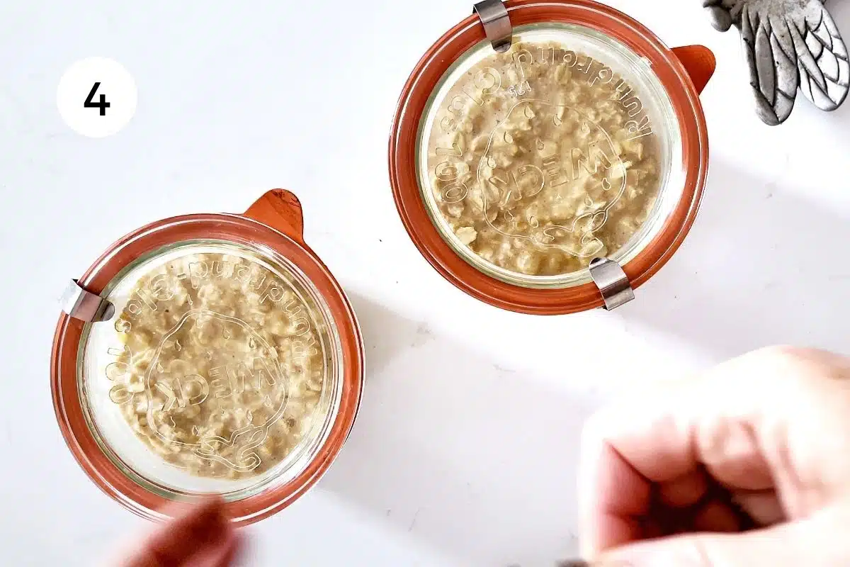 Two jars of overnight oats are sitting on a white benchtop. The lids have just been put on.