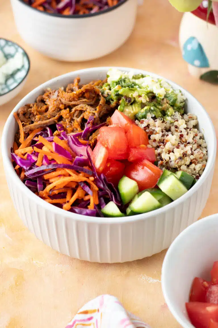 A grain bowl filled with shredded brisket, quinoa and an abundance of colourful vegetables.