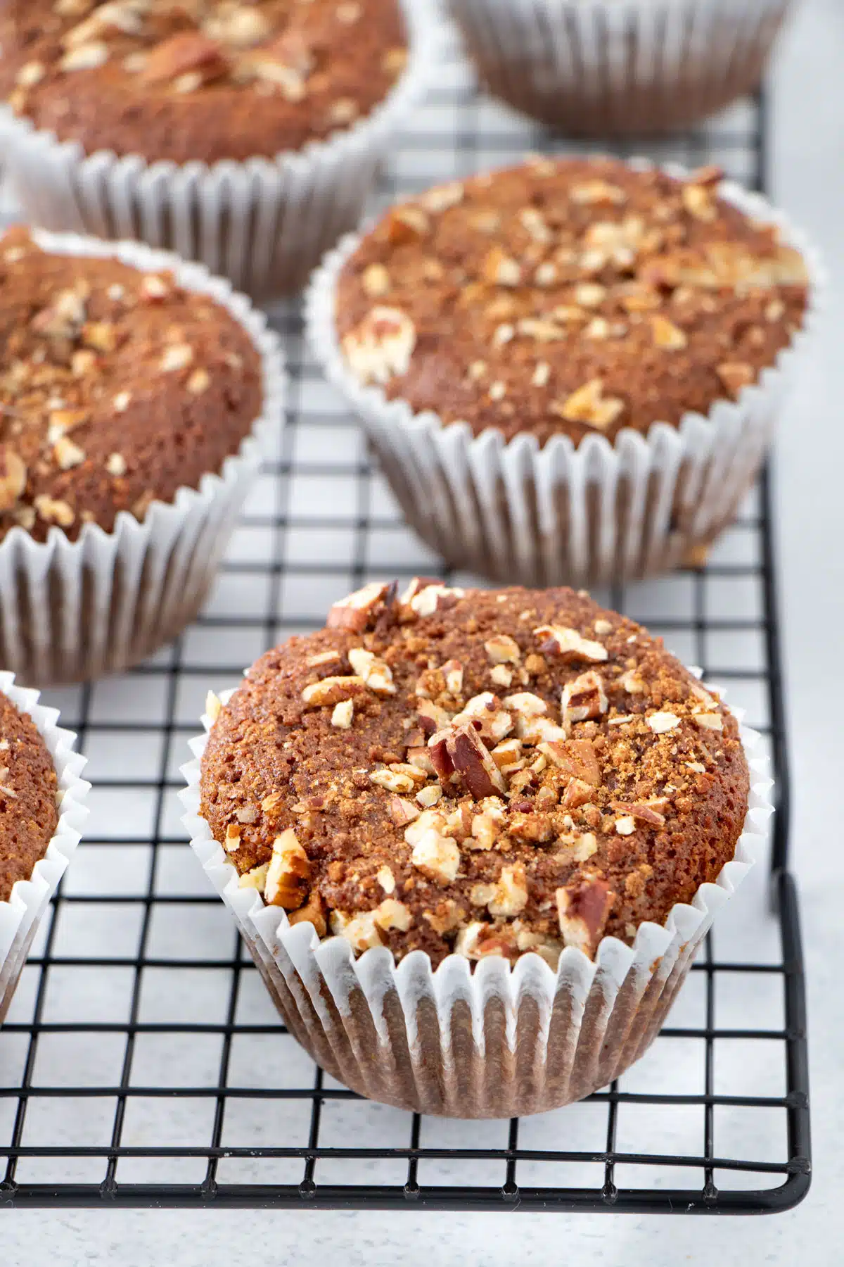 Gluten-free banana muffins are cooling on a black wire rack.