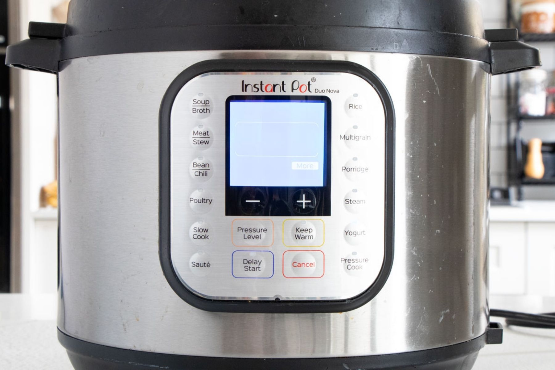 The screen of an instant pot is lit up showing the word more.