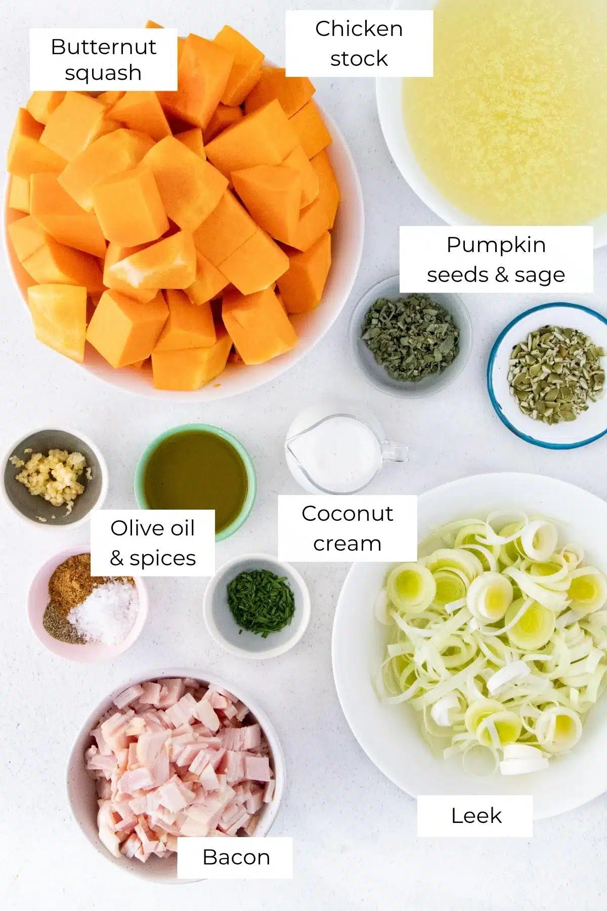 All the ingredients needed to make Instant Pot Pumpkin Soup are laid out across a table in small bowls.