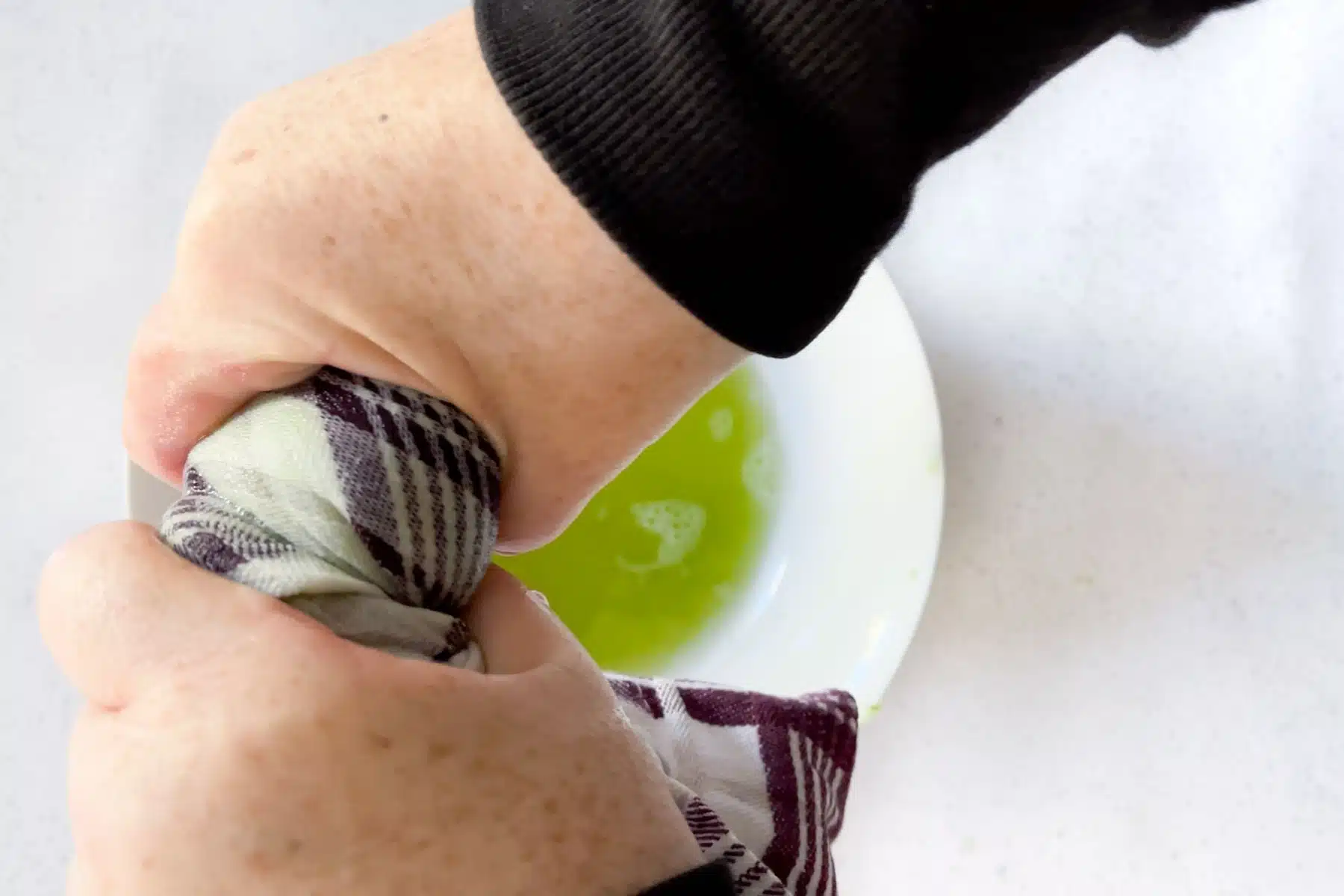 Squeezing the excess liquid out of grated cucumber used for tzatziki dip.